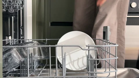 Female hands unloading clean white plates from a modern dishwasher machine .. Stock Footage 346159064
