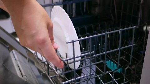 Female hands unloading dishwasher machine with a white plate close up Stock Footage 257121096