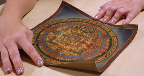 Female hands unrolling on a table a scroll with a picture of a tank representing Stock Footage 229898537