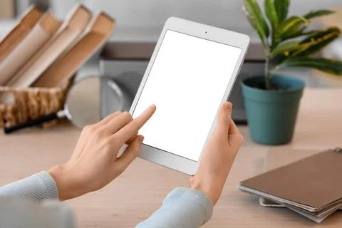 Female hands using blank tablet computer at home, closeup Foto stock