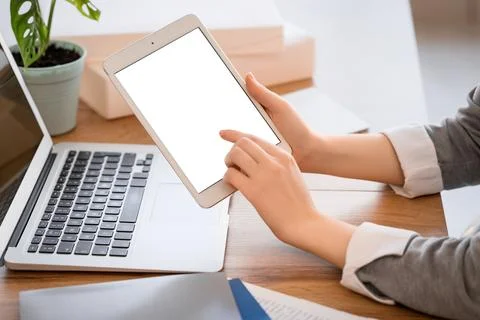 Female hands using blank tablet computer at table in office, closeup Stock Photos