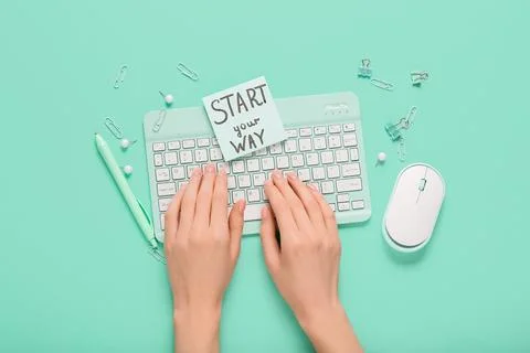 Female hands using computer keyboard and paper with text START YOUR WAY on tu Stock Photos