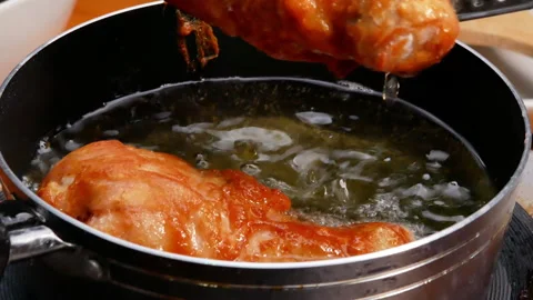  Female hands using a culinary tongs to flip chicken thighs in hot oil. Видео 157898280