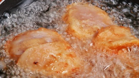  Female hands using a culinary tongs to flip chicken thighs in hot oil. Stock Footage 157898371