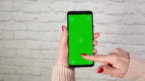 Female hands using green screen chroma key phone in vertical position Stock Footage 268031355