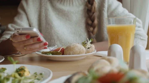 Female hands using mobile phone during her breakfast. Stock Footage 56321428