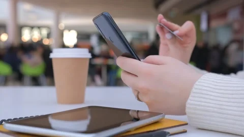 Female hands using modern smartphone . Young girl sitting at bench in shopping Stock Footage 241129479