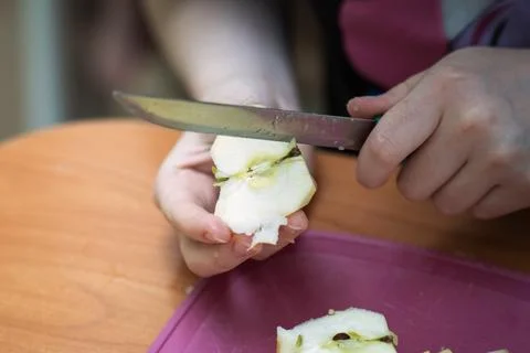 Female hands using an old knife to core an apple for cooking, ideal for foo.. Foto stock