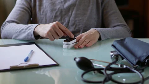 Female hands using pulse oxymeter measuring blood  oxygen  level at home fo.. Stock Footage 304794811