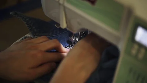 Female hands using sewing machine to stitch patch to denim jacket Vídeos de archivo 76539267