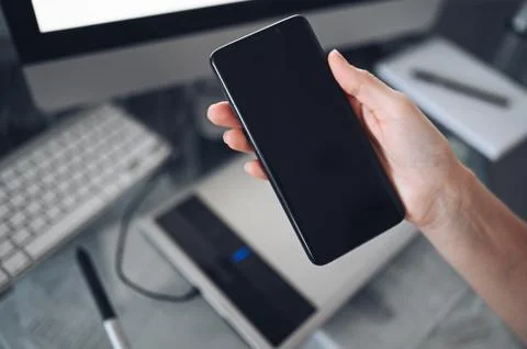 Female hands using smart phone in interior workplace Foto stock