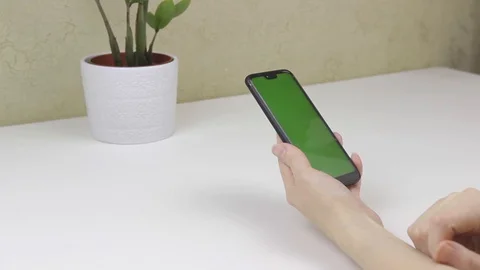 Female hands using a smartphone with green screen Stock Footage 127835618