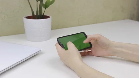 Female hands using a smartphone with green screen Stock Footage 127837653