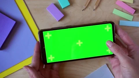 Female hands using smartphone with green screen on wooden background, top view Stock Footage 201413164