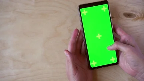 Female hands using smartphone with green screen on wooden background, top view Stock Footage 201459683