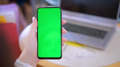 Female hands using smartphone mobile with empty green screen top view sunshine Stock Footage 258654168