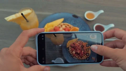 Female hands using smartphone to take photos of waffle with red fruits and mango Stock Footage 172442152