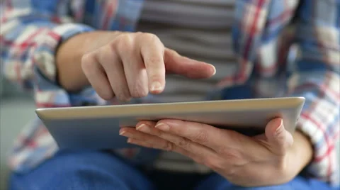Female hands using tablet PC on sofa Stock Footage 54779688