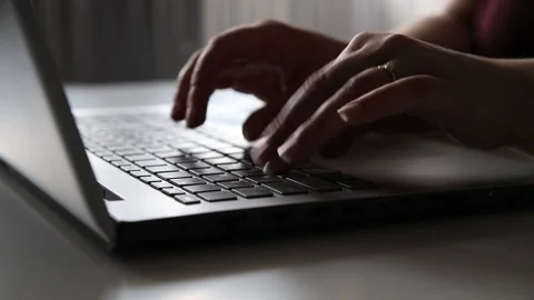 Female hands using text input on the keyboard of a silver gray laptop Stock Footage 153473732