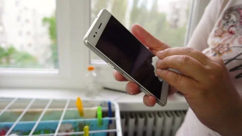 Female hands wipe smartphone screen with a napkin Stock Footage 134697641
