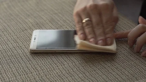 Female hands wiping surface screen mobile phone with cloth close up Stock Footage 83809760