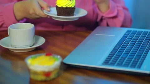 Female hands work on a computer, eat cakes and take coffee. Видео 121004998