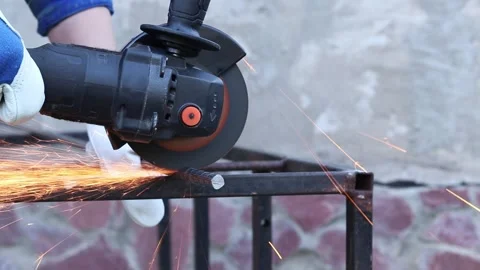 Female hands in work gloves hold a cordless grinder and cut rebar Video stock 317023583
