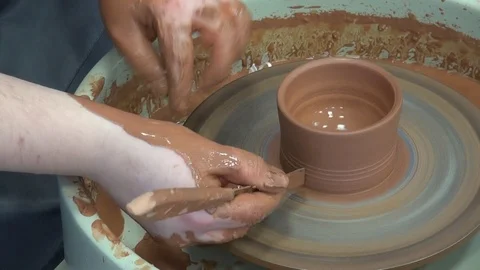 Female hands work on a potter's wheel with clay Stock Footage