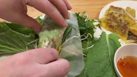 Female hands wrap Spring Roll scrambled eggs with vegetables in rice paper Stock Footage 306595559