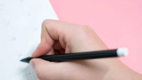 Female hands write in a calendar on pink background, concept of planning. Stock Footage 218340334