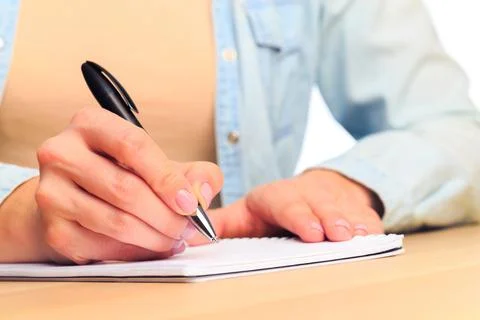Female hands write in a notebook . Office place Stock Photos