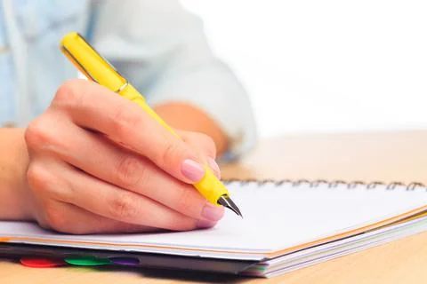 Female hands write in a notebook . Office place Stock Photos