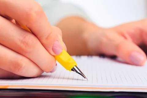 Female hands write in a notebook . Office place Stock Photos