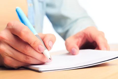 Female hands write in a notebook . Office place Stock Photos