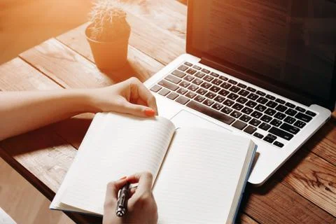 Female hands write to notebook Stock Photos
