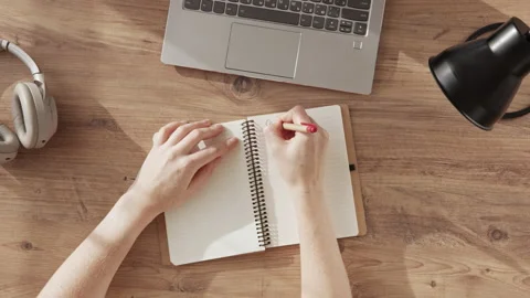 Female hands write with pen phrase online education in notebook, top down view Stock Footage 231081478