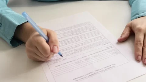 Female hands write with a pen on a sheet of paper, fill out a questionnaire Stock Footage 163153647