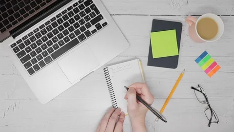 Female hands writing a To Do List on a notepad at a wooden desk. Stock Footage 121892434