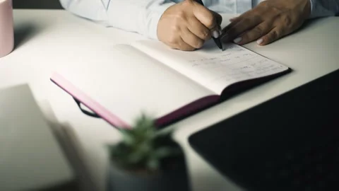 Female hands writing in notebook close up handheld shot in slow motion 4k Stock Footage 343449548