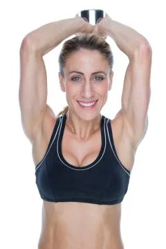 Female happy bodybuilder working out with large dumbbell behind head Stock Photos