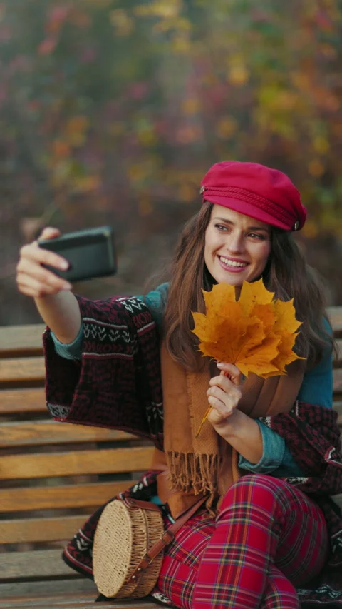 Female having video meeting while sitting on bench in city park Stock Footage 284737871