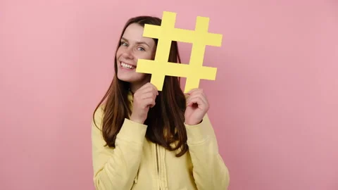 Female hides face behind big hashtag symbol, advertising blog, internet trends Stock Footage
