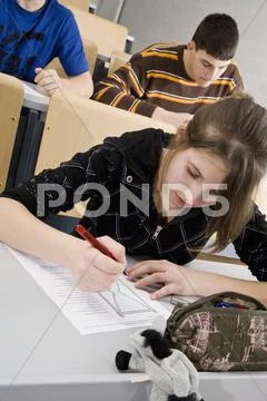 A female high school student doing school work in a classroom Stock Photos