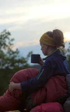 Female hiker drinking while caming Stock Photos