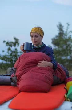 Female hiker drinking while caming Stock Photos