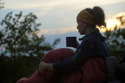 Female hiker drinking while caming Stock Photos