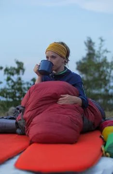 Female hiker drinking while caming Stock Photos