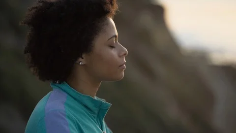 Female hiker meditating on mountain Stock Footage