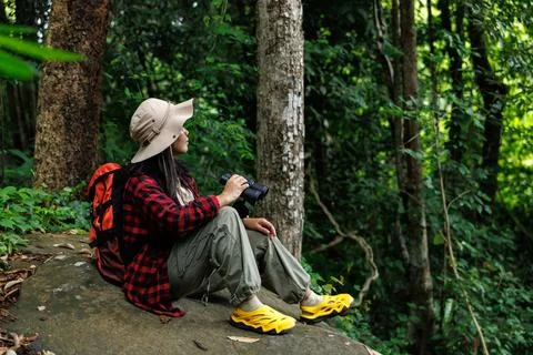 Female Hiker Using Binoculars While Resting In Lush Forest Horizontal Shot Stock Photos