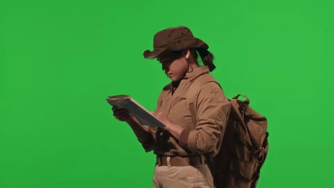 Female Hiker Using Orienteering Map on Green Chroma Key Wall Stock Footage 268828005